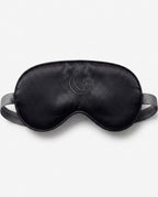 Black silk eye mask with embroidered crescent moon, showing smooth weave