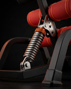 Macro of the steel coil spring and orange adjustment knob on the bench