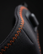 Macro of the orange zigzag stitching on the black neoprene comfort mask edge