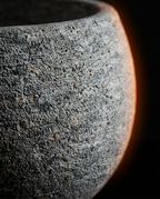 Macro close-up of the raw textured surface of the natural stone bowl