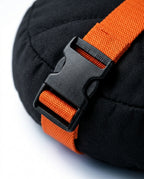 Macro of the orange strap and black quick-release buckle on the ankle cushion