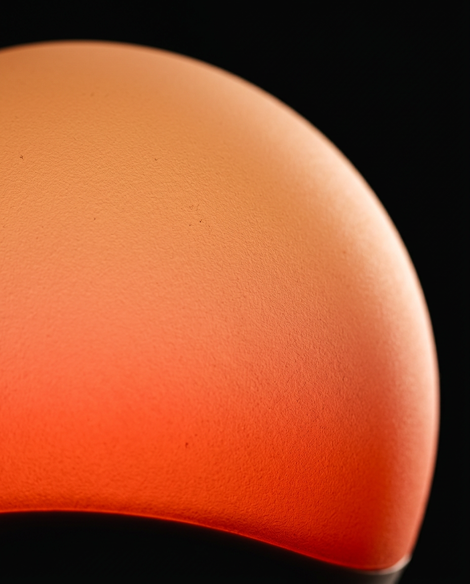 Macro of the warm orange sunrise gradient glow across the lamp dome