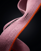 Close-up of the pink resistance band's woven weave with orange edge