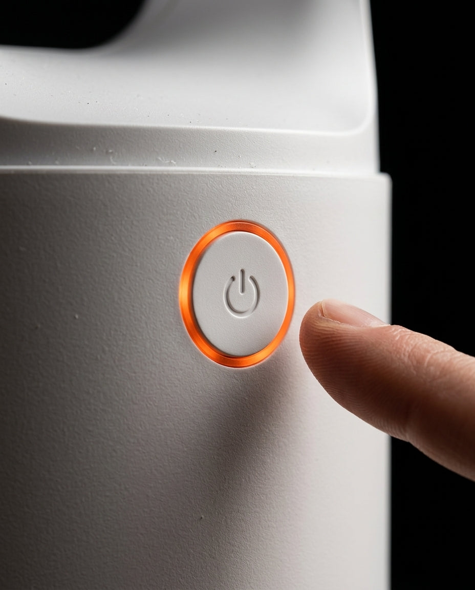 Finger reaching for the power button ringed in glowing orange on the fan