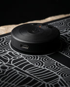Macro of the round black control hub with power button and USB-C on the foot mat