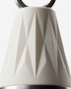 Macro detail of the faceted diamond-textured cream body of the face massage tool