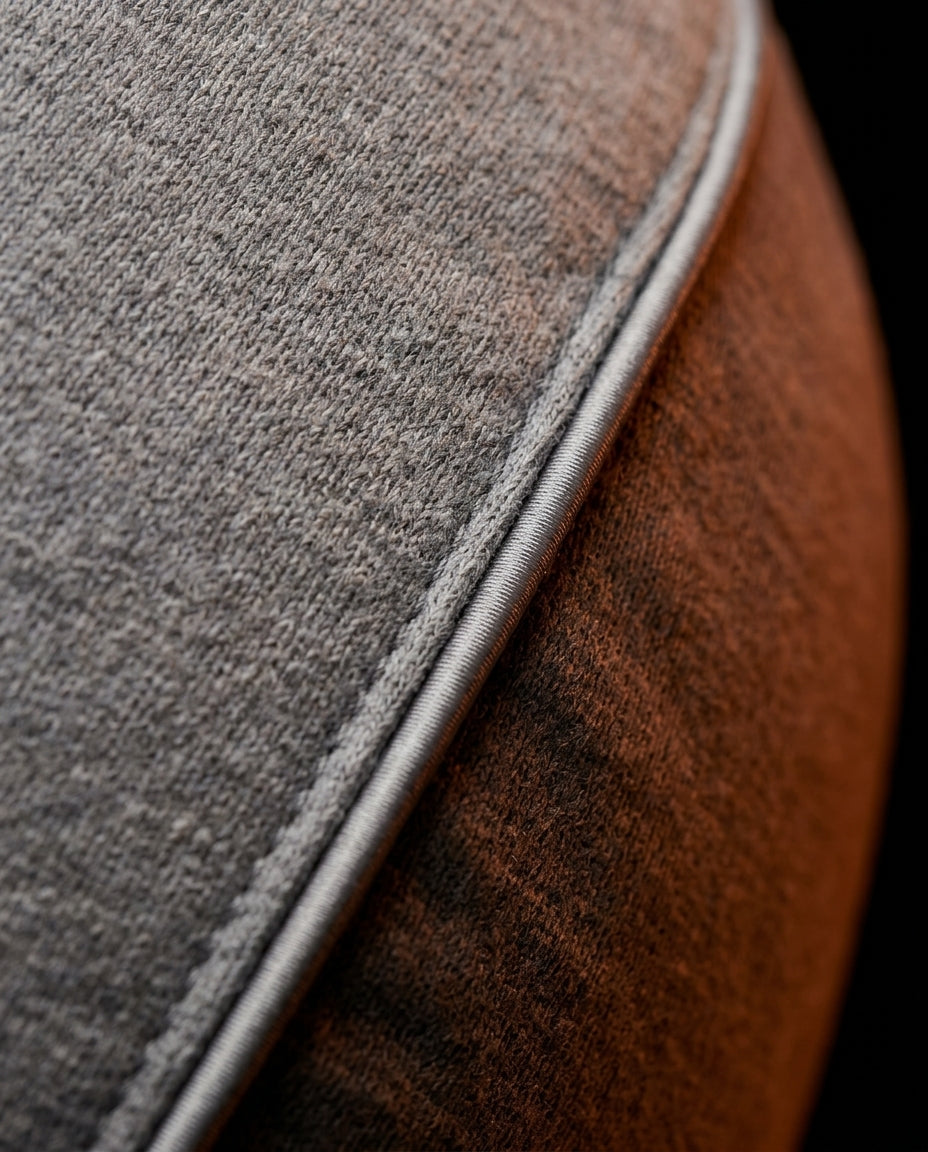 Macro of the grey knit fabric weave and piped seam of the feeding pillow