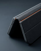 Close-up of the flexible fold hinge of the dark bath mat with orange trim