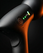 Macro of the power button and LED speed indicator on the massage gun grip