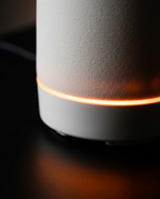 Macro of the warm glowing LED ring at the base of the ceramic diffuser