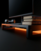 Riser supporting a monitor, books and dumbbell showing load capacity