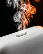 Macro of aroma mist rising from the diffuser's top outlet slot