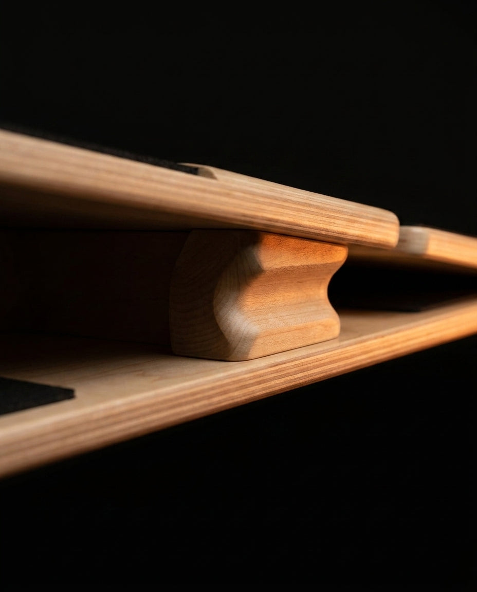 Close-up of the wooden pivot rocker mechanism beneath the balance board