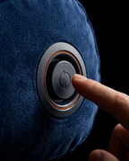 Finger pressing the push-button air valve on the inflatable wedge pillow