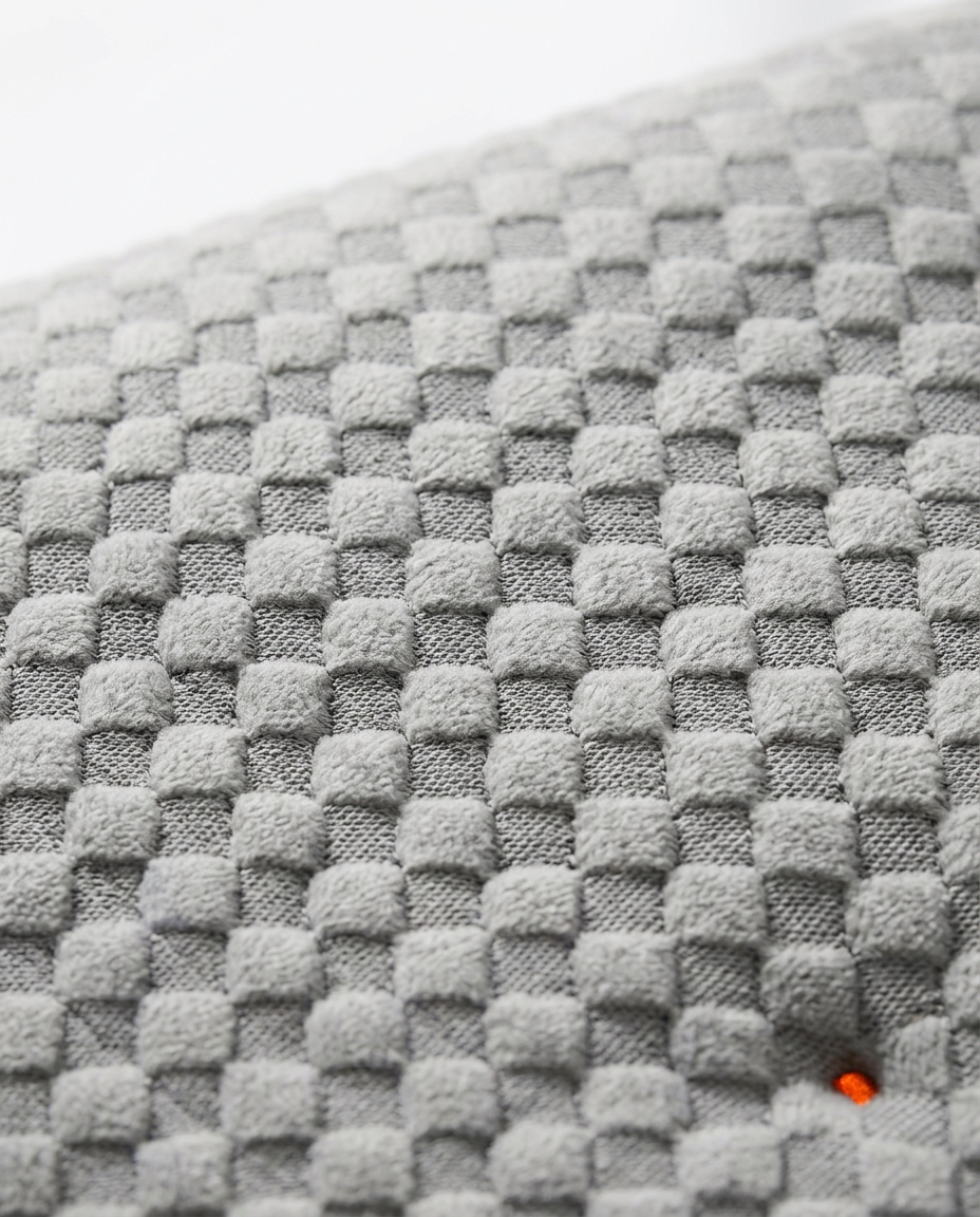 Macro close-up of the soft grey quilted waffle-textured pillow fabric