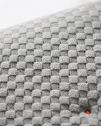 Macro close-up of the soft grey quilted waffle-textured pillow fabric