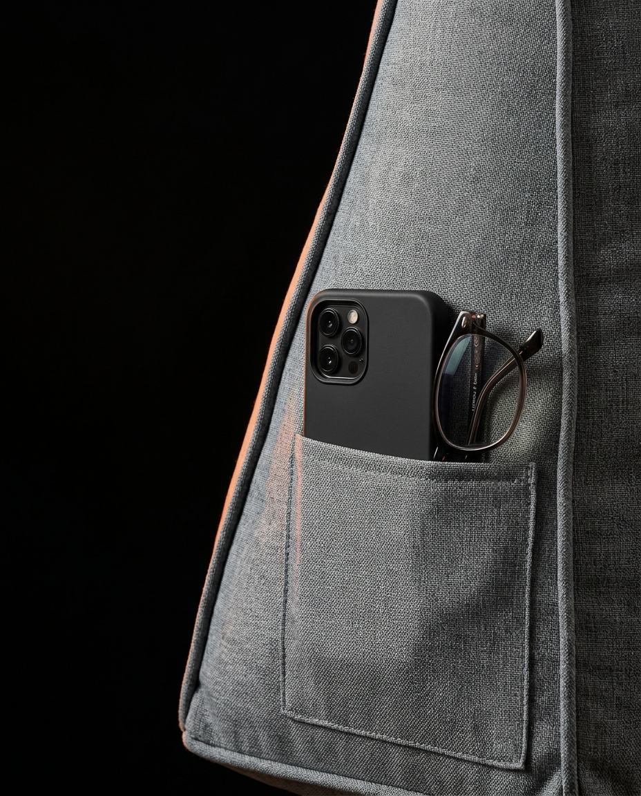 Side pocket of the grey backrest cushion holding a phone and glasses
