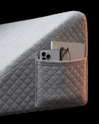 Side storage pocket holding a phone, book and glasses on the wedge pillow