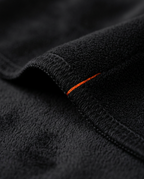Macro of the stitched edge with orange accent tab on black fleece