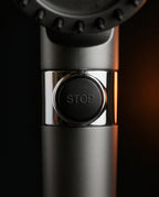 Macro of the shower head's chrome-rimmed STOP water-pause button