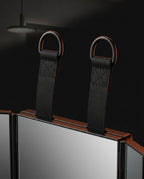 Macro of the two hanging straps and D-ring hooks atop the folding mirror