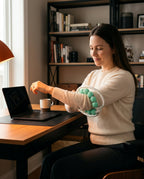Woman rolling the green massage ring on her forearm during an office break