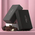 Two black foam yoga blocks staged on a pink set, showing chamfered edges