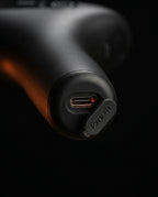 Macro of the USB-C charging port at the base of the massage gun handle