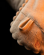 Macro of the knit fabric base with hanging loop and embroidered flame logo