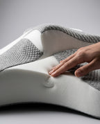 Hand pressing into high-density white memory foam to show rebound