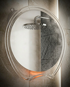 Close-up of the shower mirror's fog-free surface reflecting a showerhead through steam