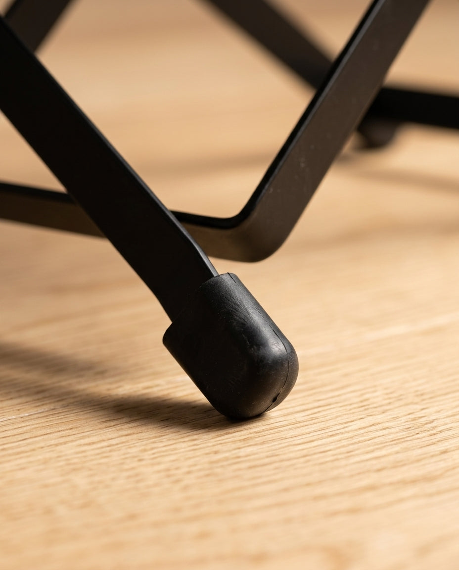 Macro of the footrest's rubber foot cap gripping a wood floor