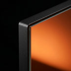 Macro of the mirror's clear glass surface and rounded black frame corner