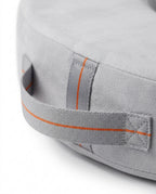Macro of the grey carry handle with orange stitching on the feeding pillow