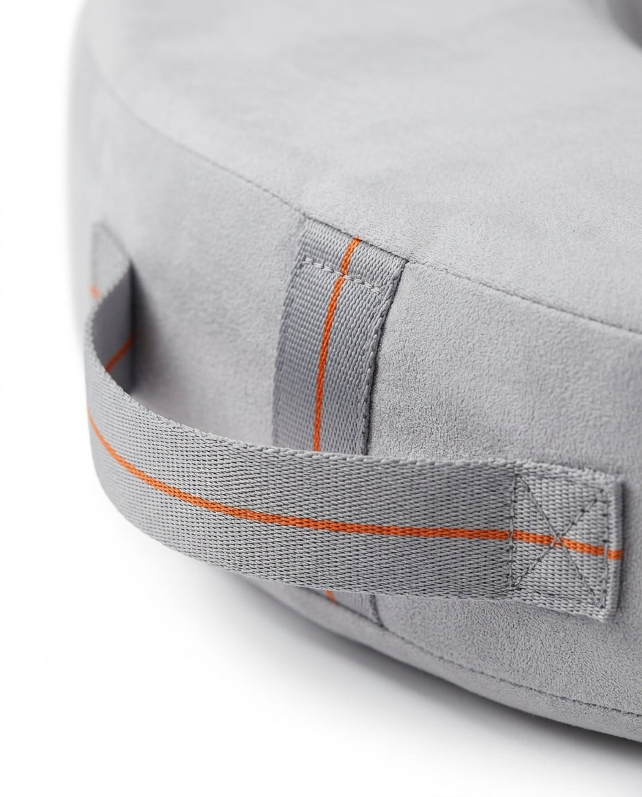 Macro of the grey carry handle with orange stitching on the feeding pillow