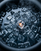Top-down macro of ice cubes floating in the dark ice bath water
