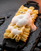 Back scrubber mesh loofah lathering rich foam on a wet stone surface