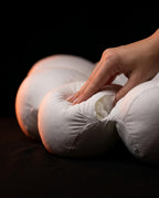 Hand pressing into the pillow to show slow-recovery memory fiber loft