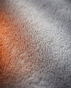 Macro of the plush grey exterior fleece fading into a warm orange glow