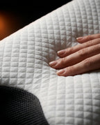 Hand pressing the soft quilted cover of the memory foam cervical pillow