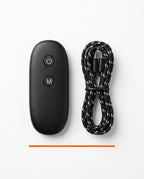 Black wireless remote beside a braided USB-C charging cable on white