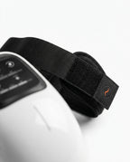 Close-up of the adjustable velcro strap and Pyre Fit logo on the knee massager
