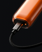 USB-C cable plugged into the charging port of the orange precision trimmer