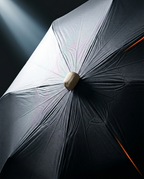 Light passing over the silver UV-coated canopy of the open umbrella