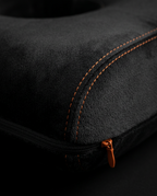 Macro of the soft black velour fabric with orange stitching and zipper