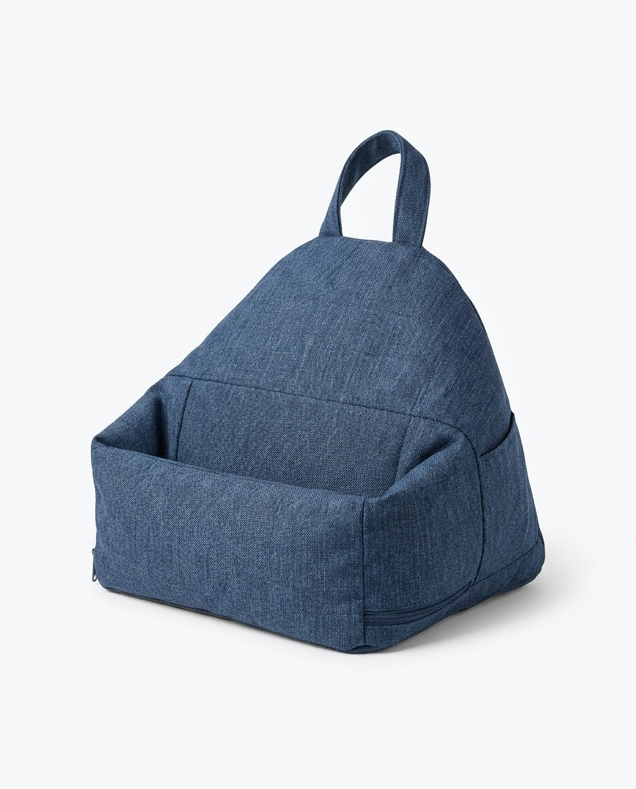 Denim blue tablet stand pillow shown at an angle with handle and pocket