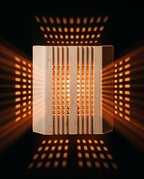 Sauna light cover glowing in the dark, projecting patterned light on walls