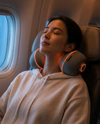 Woman napping in an airplane seat wearing the glowing neck massage pillow