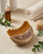 Facial ritual comb styled on a vanity with serum, towel, candle and eucalyptus