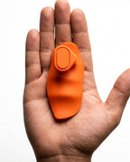 Open palm holding single orange silicone grip pad showing compact size